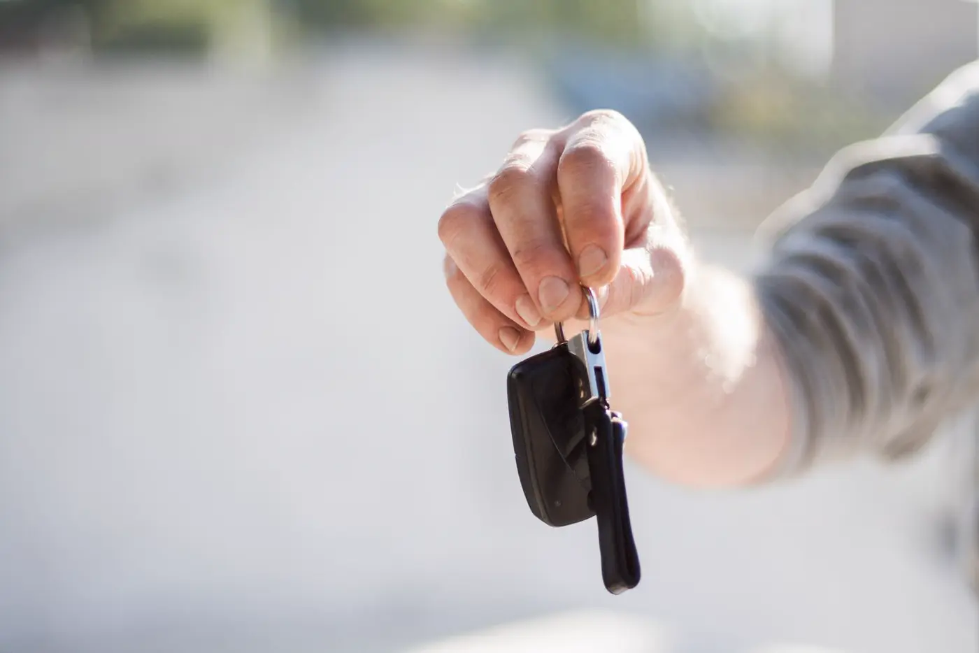 Hand holding out a set of car keys